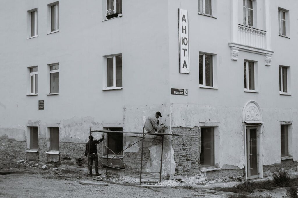 Workers renovating wall of residential house